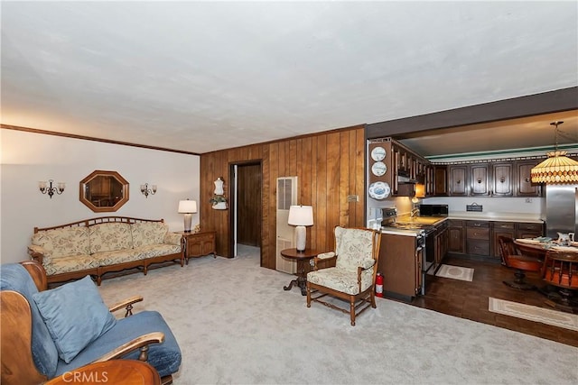 carpeted living room featuring wood walls