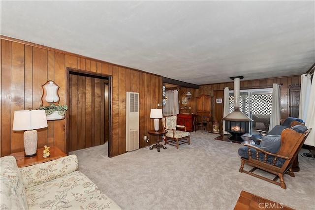 carpeted living room with wood walls