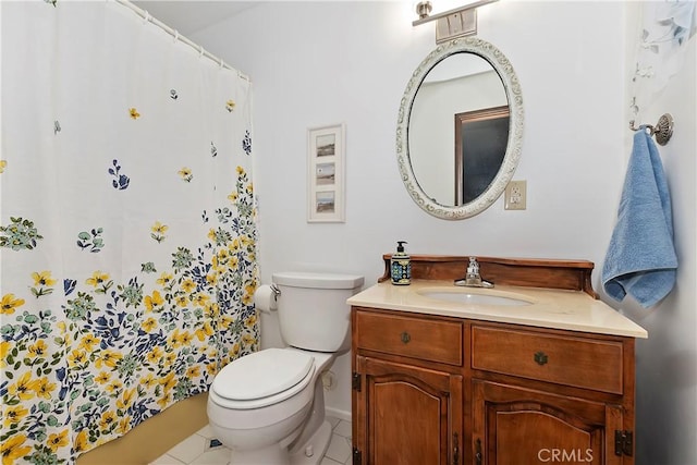 bathroom with toilet, vanity, and tile patterned flooring