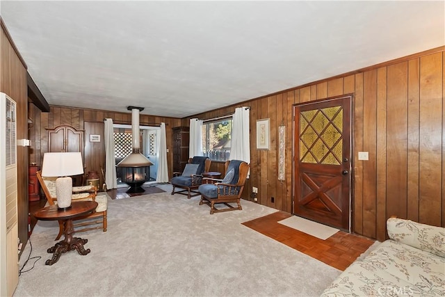 carpeted living room with wooden walls