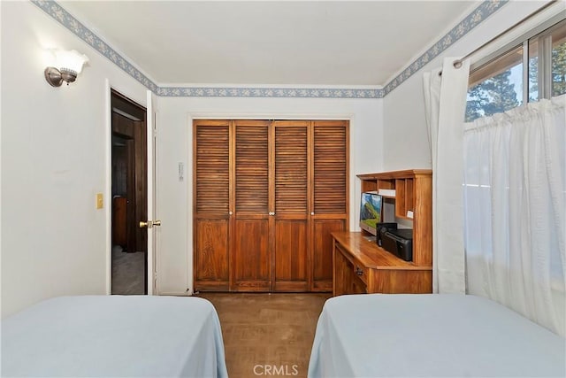 bedroom featuring light parquet flooring and a closet