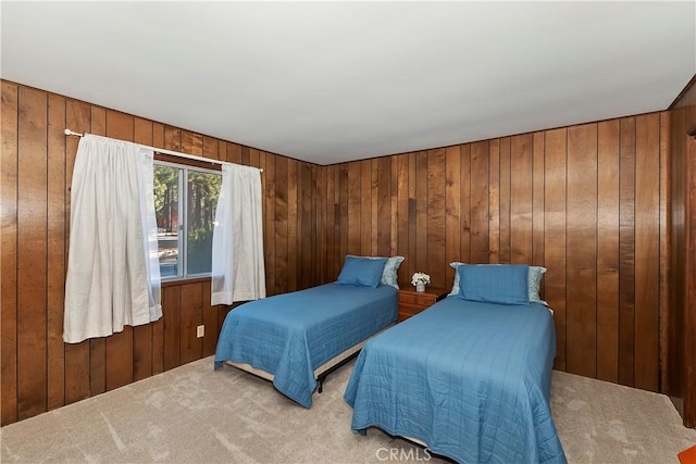 bedroom featuring light colored carpet and wooden walls