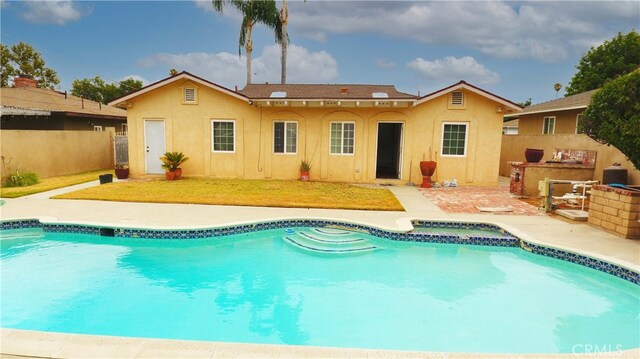 back of house with a patio area, a fenced in pool, and area for grilling