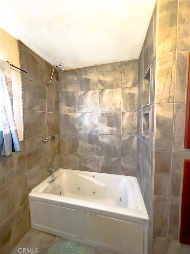 bathroom with a combined bath / shower with jetted tub, tile walls, and tile patterned floors