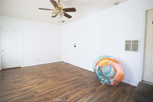 unfurnished room with ceiling fan, visible vents, and dark wood-type flooring