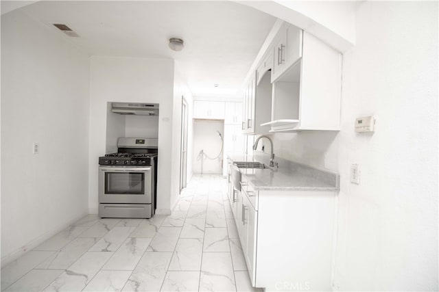 kitchen with gas stove, marble finish floor, white cabinetry, and under cabinet range hood