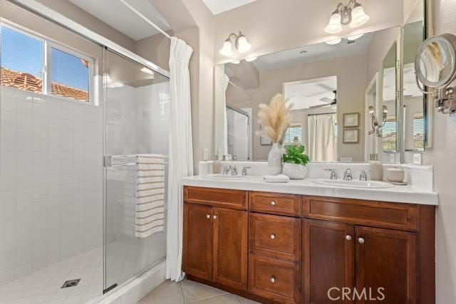 bathroom with tile patterned floors, a wealth of natural light, and a shower with shower door