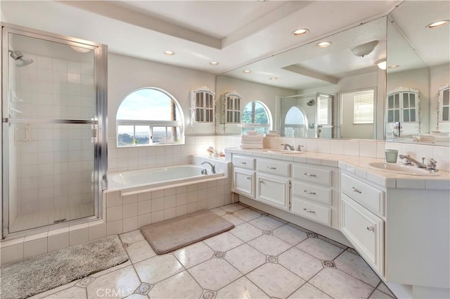 bathroom with tile patterned floors, a tray ceiling, vanity, and independent shower and bath