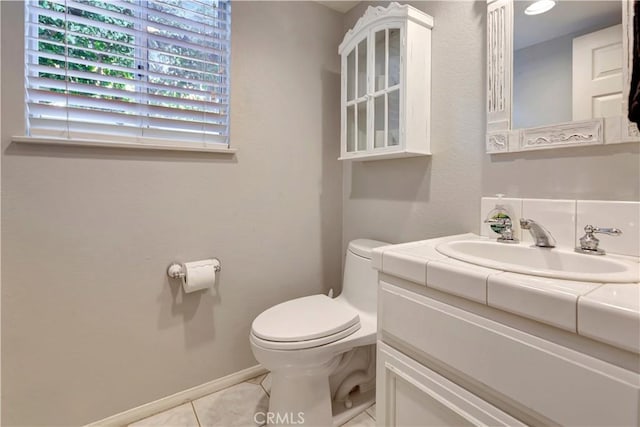 bathroom featuring toilet, tile patterned flooring, and vanity