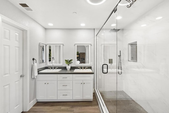 bathroom featuring vanity, wood-type flooring, and a shower with door