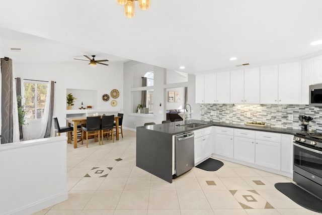 kitchen featuring white cabinets, stainless steel appliances, tasteful backsplash, sink, and ceiling fan