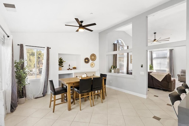 dining space featuring ceiling fan, light tile patterned floors, and vaulted ceiling