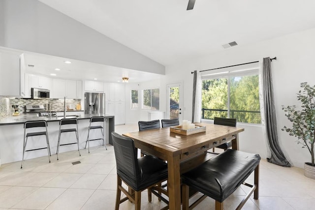 tiled dining area with lofted ceiling