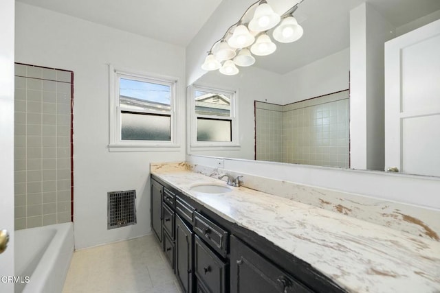 bathroom with vanity and tiled shower / bath