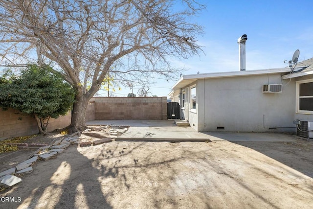 view of yard with central air condition unit, a patio, and a wall mounted air conditioner