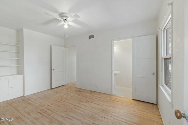 unfurnished bedroom with light wood-type flooring, ceiling fan, and connected bathroom