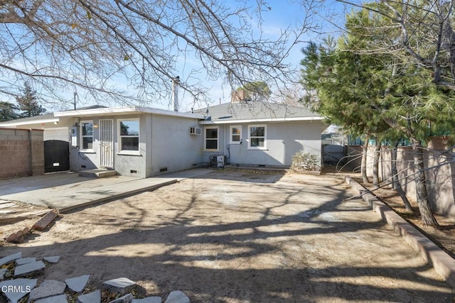 rear view of property with a patio area, central AC, and an AC wall unit