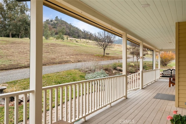 wooden deck featuring a mountain view and covered porch