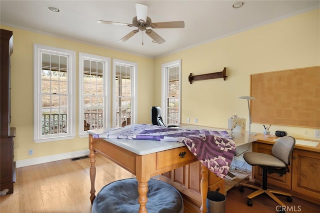 office space with ceiling fan, ornamental molding, and light hardwood / wood-style flooring