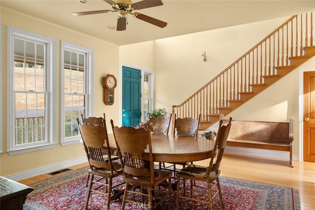 dining area featuring ceiling fan, ornamental molding, and light wood-type flooring