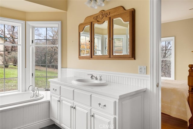 bathroom featuring vanity, a bathing tub, and crown molding