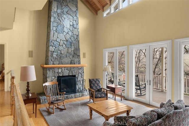 living room with french doors, a fireplace, light hardwood / wood-style floors, high vaulted ceiling, and wooden ceiling