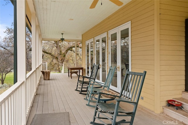 wooden terrace with ceiling fan, french doors, and covered porch