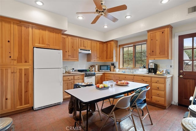 kitchen featuring ceiling fan, a wealth of natural light, white appliances, and tasteful backsplash