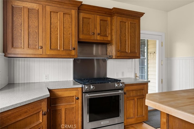 kitchen featuring stainless steel gas stove and wall chimney range hood