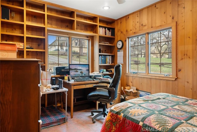 bedroom featuring multiple windows and wooden walls