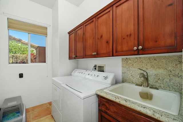 washroom featuring washer and dryer, sink, light tile patterned floors, and cabinets