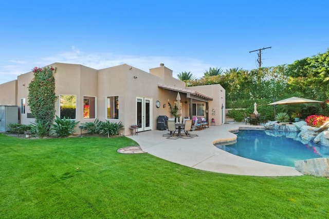 back of house featuring a patio area and a lawn