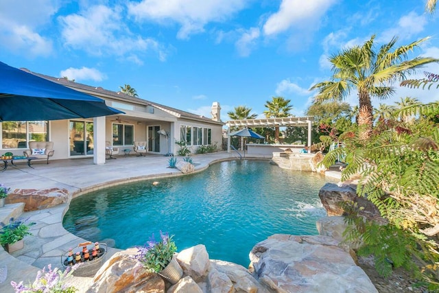 view of pool with a pergola, a patio area, pool water feature, and ceiling fan