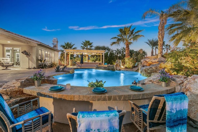 pool at dusk featuring a pergola, a patio area, and pool water feature