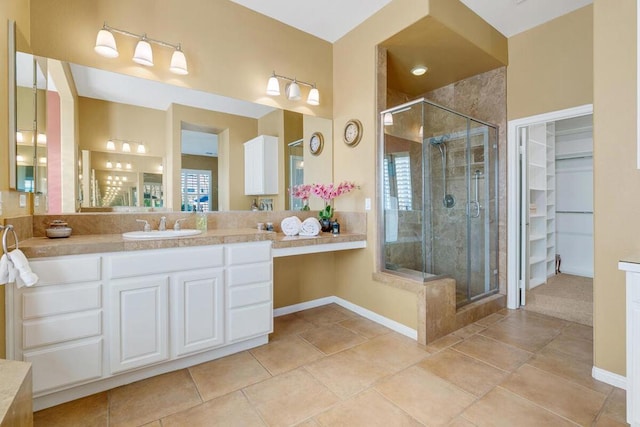 bathroom with tile patterned floors, vanity, and a shower with door