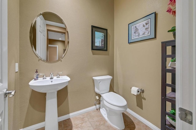 bathroom featuring tile patterned floors, toilet, and sink