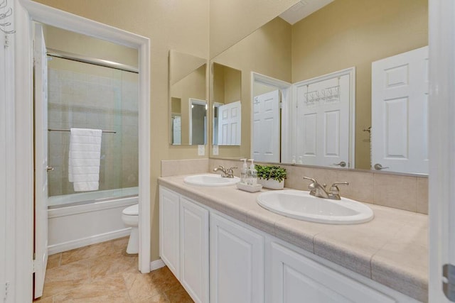 full bathroom with enclosed tub / shower combo, vanity, and toilet