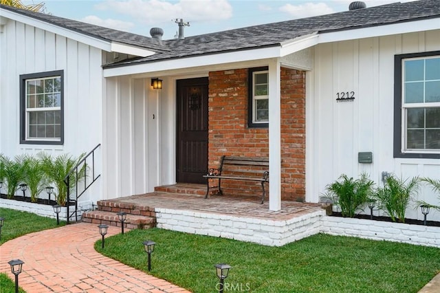 view of exterior entry with a lawn