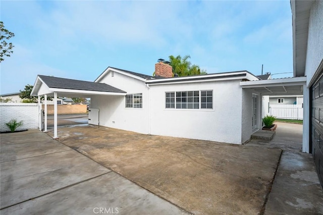 back of property with a carport