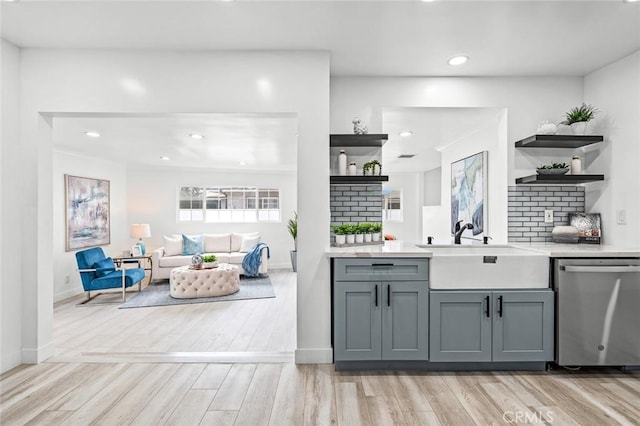 bar with dishwasher, sink, gray cabinetry, decorative backsplash, and light hardwood / wood-style floors