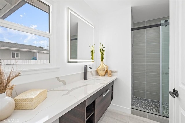 bathroom with a shower with door and vanity