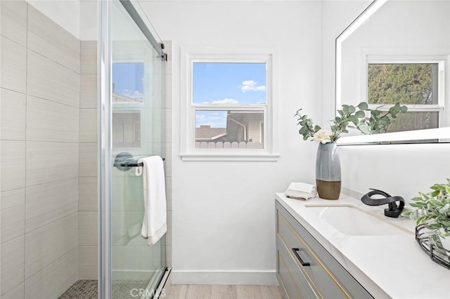 bathroom featuring vanity, a shower with shower door, and hardwood / wood-style floors