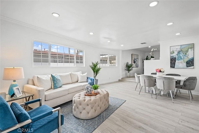 living room featuring crown molding and light hardwood / wood-style floors