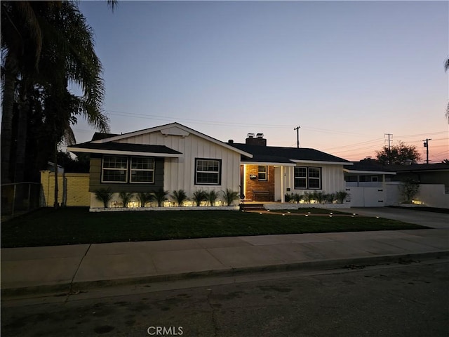 ranch-style home featuring a lawn