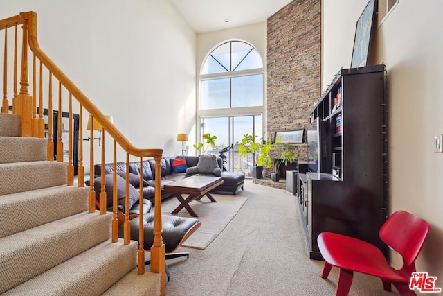 carpeted living room featuring a high ceiling