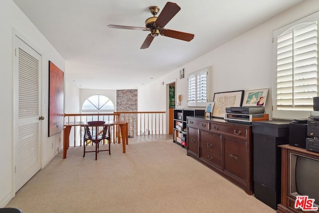 carpeted office space featuring ceiling fan and plenty of natural light