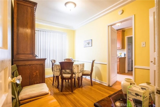 dining area with ornamental molding and light wood-type flooring