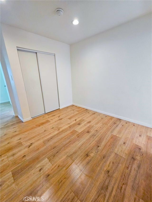 unfurnished bedroom featuring a closet and light hardwood / wood-style flooring