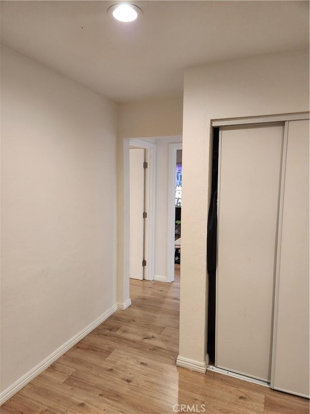 hallway with light hardwood / wood-style floors