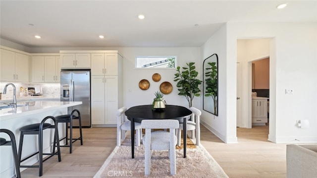 dining area with light hardwood / wood-style floors and sink